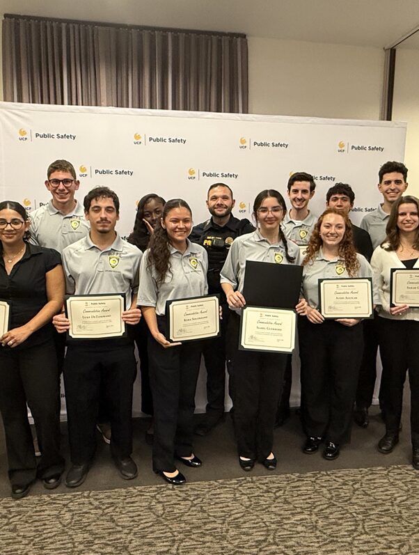 One police officer and thirteen explorers posing for a group photo after receiving awards